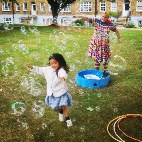Child chasing bubbles in a garden