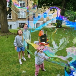 First birthday bubble entertainment in London with baby and children playing with giant bubbles