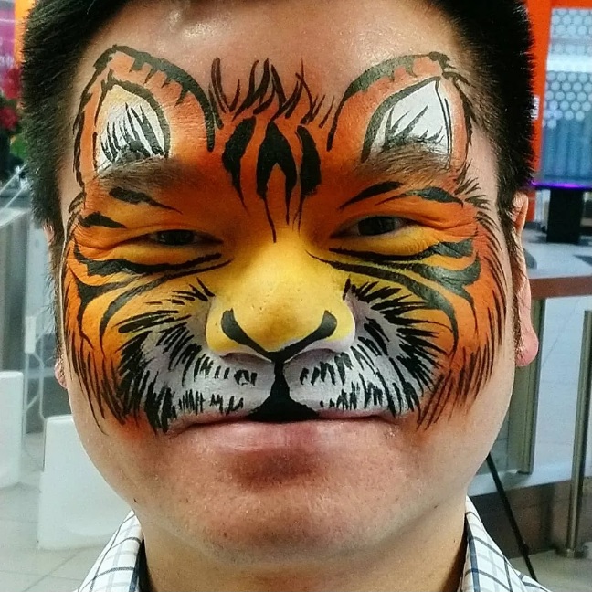 Face paint of tiger design on an adult