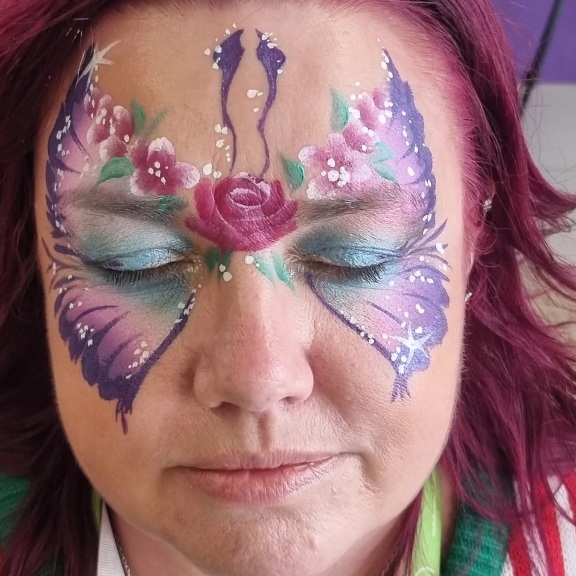 Purple butterfly face paint on an adult