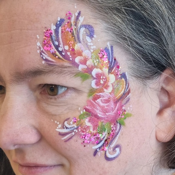 Flowery face paint design with glitter