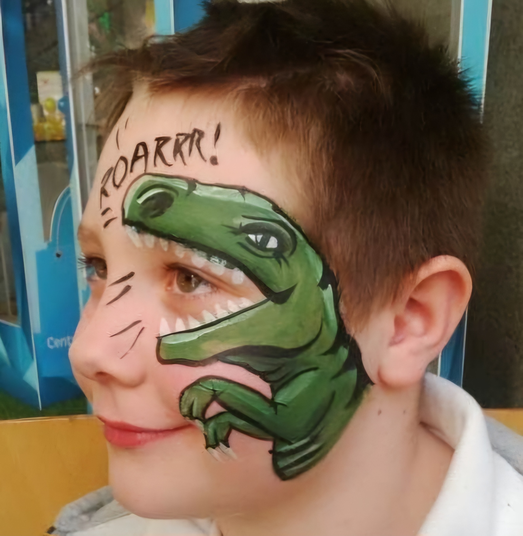 Boys face painting of a dinosaur at a children's party