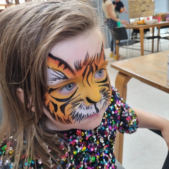 Face paint design of a tiger on girl Face paint design of a tiger on girl