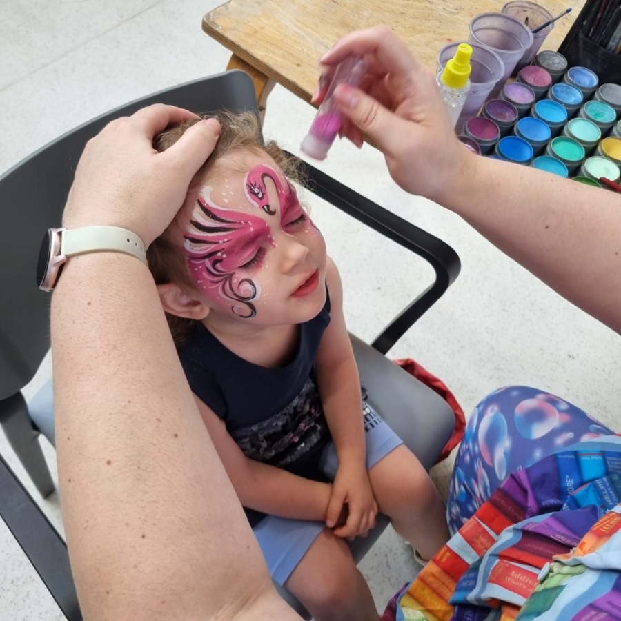 Professional face painter painting a child at a party