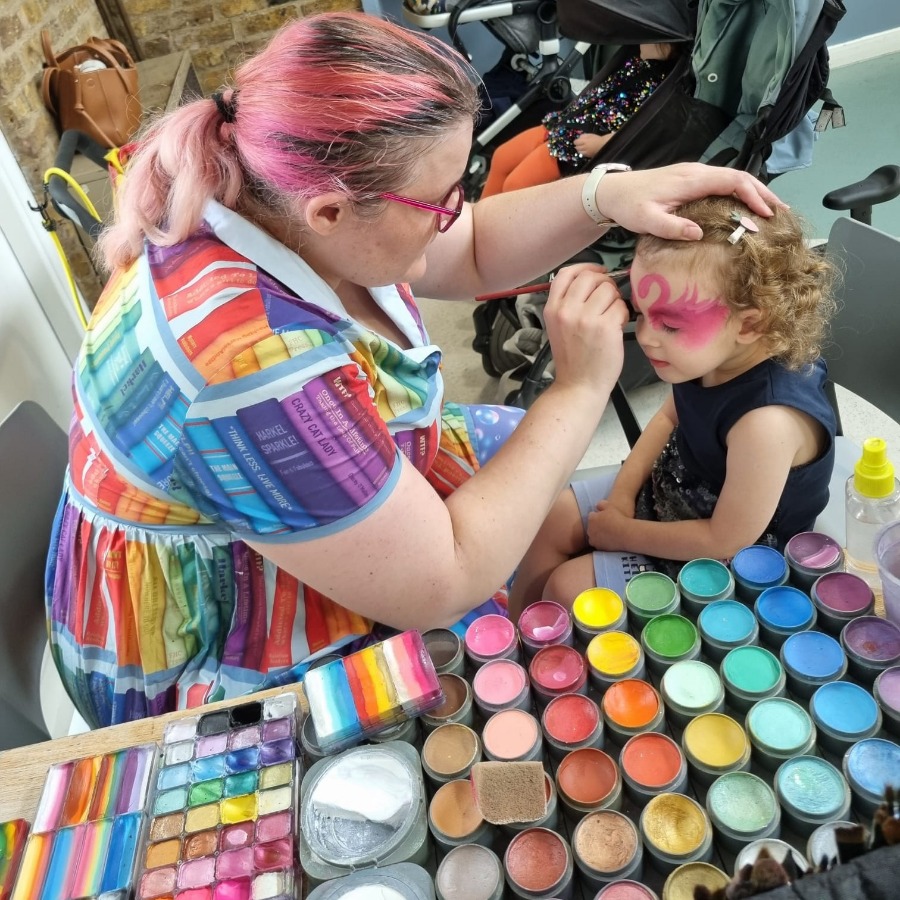 Professional face painter painting a child at a party