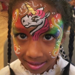 Child face painted as a rainbow unicorn, a standard face painting design