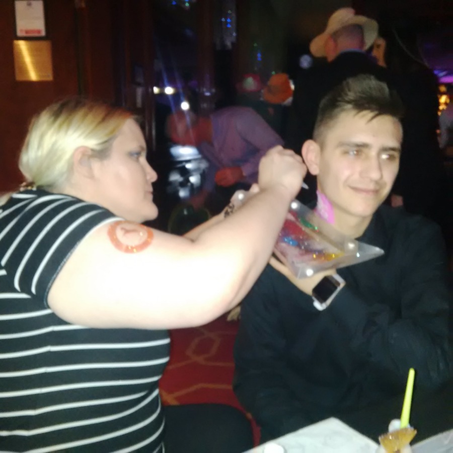 Professional glitter tattoos being applied at a party Professional glitter tattoos being applied at a party