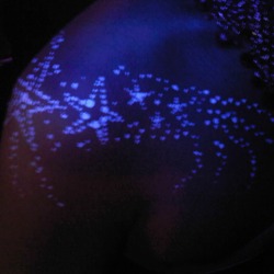 White UV neon stars design on a shoulder at a corporate event